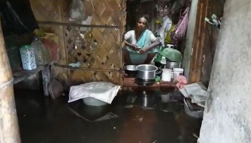রান্নাঘরে ঢুকছে বাইরের নোঙরা জল। তারই মাঝে বাধ্য রান্না করছে অসহায় বৃদ্ধা মা। কেউই এগিয়ে আসেনি। 