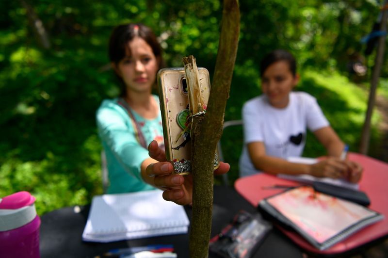 sisters attending online classes up a tree in El Salvadoran KPP