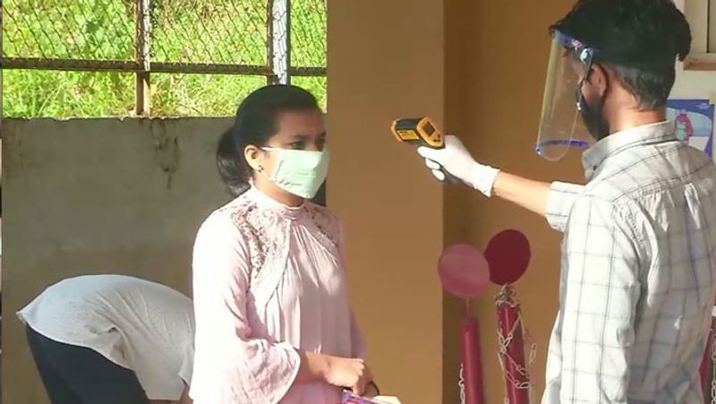 एग्जाम सेंटर में प्रवेश से पहले स्टूडेंट्स, फैकल्टी और अन्य स्टाफ का टेम्परेचर मापा जा रहा।