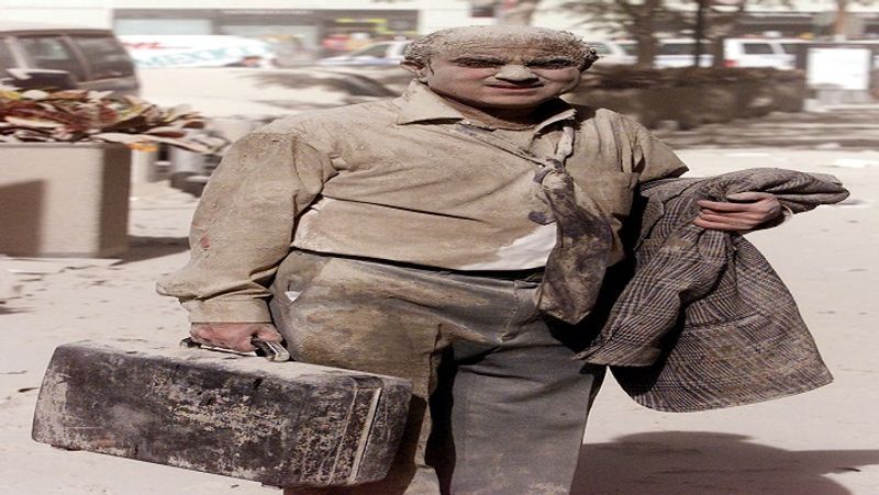 वर्ल्ड ट्रेड सेंटर के टावर्स के जल जाने के बाद में राख और धूल में नहाया वहां मौजूद एक शख्स।