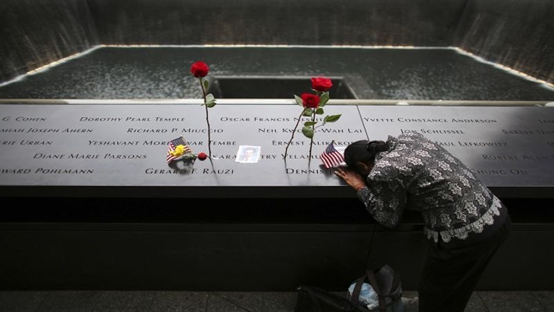 9/11 हमले की बरसी पर नॉर्थ पूल पर हमले में मारे गए लोगों के मेमोरियल पर इन्सक्राइब्ड अपने हसबैंड के नाम को देख कर शोक जताती हुई।