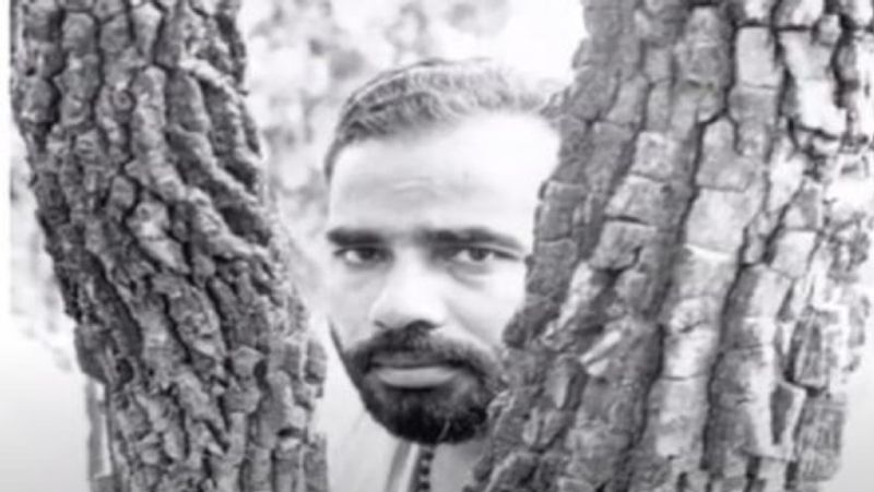 एक पेड़ के पास खड़े होकर फोटो खिंचवाते हुए पीएम मोदी।