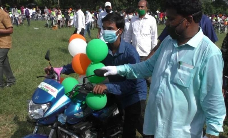 जिला टॉपर छात्र को बाइक देते हुए राज्य के शिक्षा मंत्री जगरनाथ महतो।