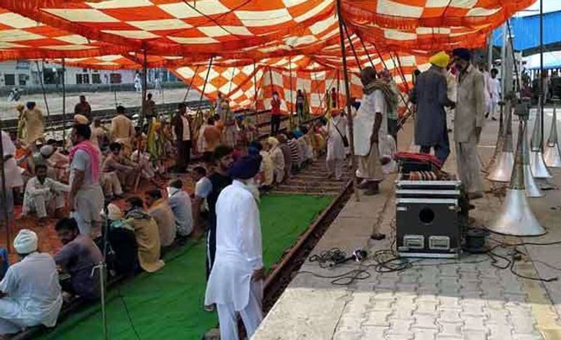 तस्वीर में देखिए बरनाला में रेलवे प्लेटफार्म और ट्रैक पर टेंट लगाकर धरने पर बैठे सरकार से खफा किसान।