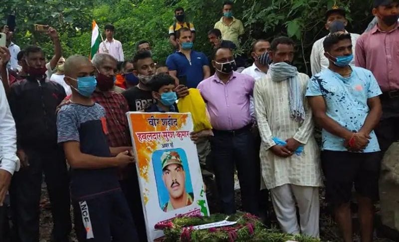 अपनी बहादुर पिता के ताबूत पर उनकी फोटो रख यूं खड़ा रहा मासूम बेटा। मानो कह रहा हो मुझे मेरे पिता पर गर्व है, वो देश की रक्षा करते करते शहीद हो गए।