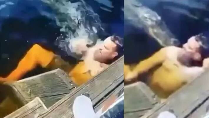Alligator attacks man swimming next to it in viral video Alligator attacks man swimming next to it in viral video
