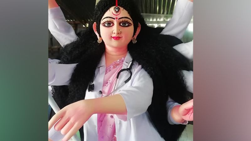 इस फोटो में दुर्गा की प्रतिमा की जगह डॉक्टर है, जो सफेद कोट में है। वे महिसासुर के आकार के कोरोना वायरस को मार रहीं हैं। खास बात ये है कि प्रतिमा के हाथ में किसी हथियार की जगह इंजेक्शन है।
