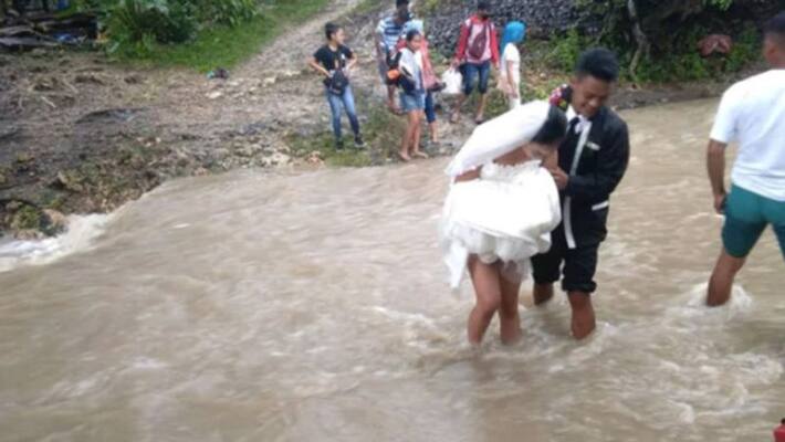 couple wades through floodwater to get married couple wades through floodwater to get married