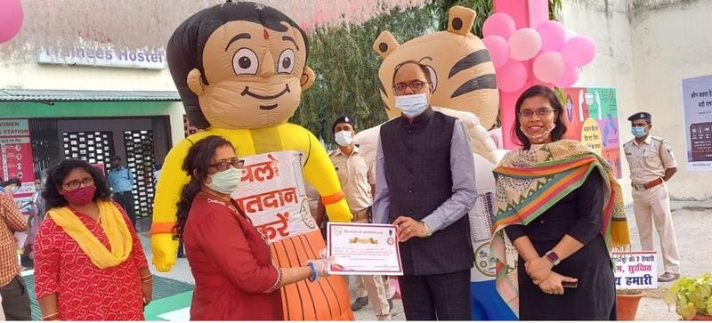 आदर्श मतदान केंद्र पर पहले मतदान करने वाले वोटर को प्रमाण पत्र देते मतदान अधिकारी।
