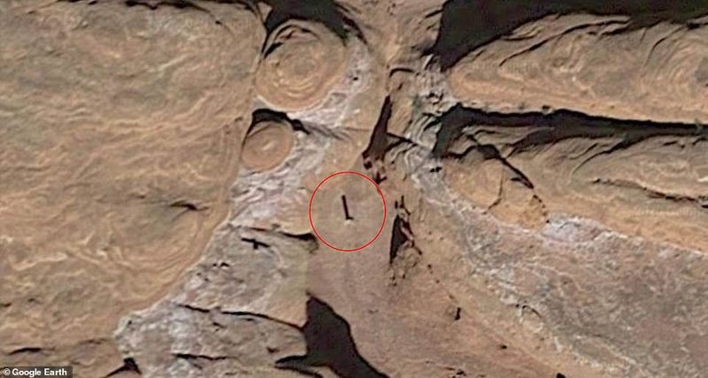 12 foot tall metal structure between the red rock mountain in Utah Desert photostory