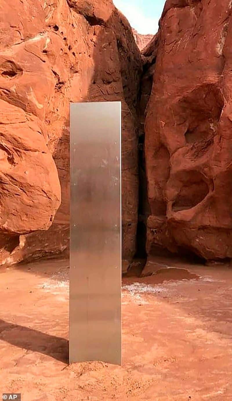 12 foot tall metal structure between the red rock mountain in Utah Desert photostory