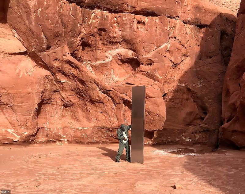 12 foot tall metal structure between the red rock mountain in Utah Desert photostory