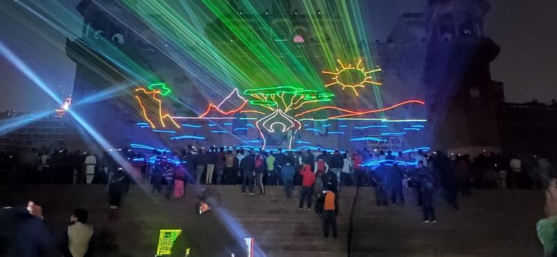 गंगा जी की लहरों पर लेजर शो के माध्यम से भगवान की महिमा देखते लोग।