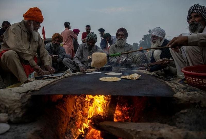 किसानों ने साफ कर दिया है कि उनके पास एक साल का राशन है। अगर उनकी मांग नहीं मानी गई तो वे इसी तरह बॉर्डर पर प्रदर्शन करते रहेंगे। (फोटो- प्रदर्शन में दौरान रोटी बनाते हुए किसान।) 