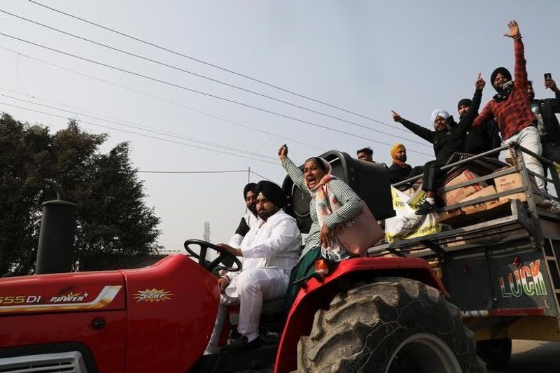 कृषि कानूनों के खिलाफ ट्रैक्टर पर बैठकर नारे लगाते किसान। 