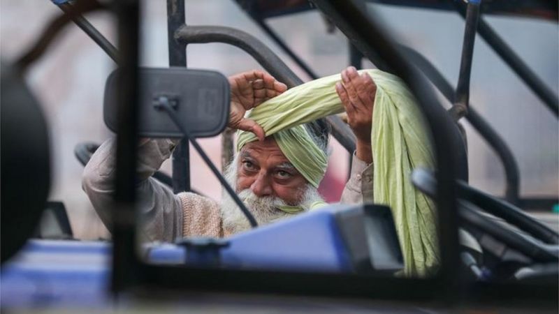 पगड़ी बांधता किसान। 