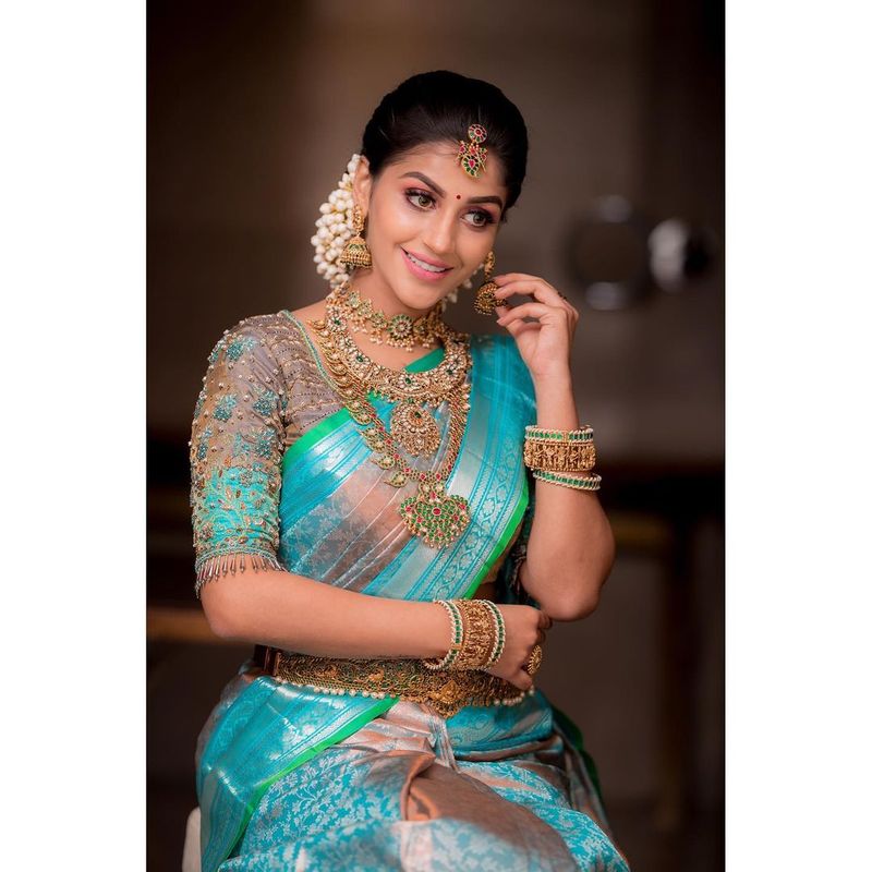 கழுத்து நிறைய பொன் நகைகள் அணிந்து அழகிய பட்டுப்புடவையில் அம்சமாக போஸ் கொடுத்து அசத்தியிருக்கிறார். 