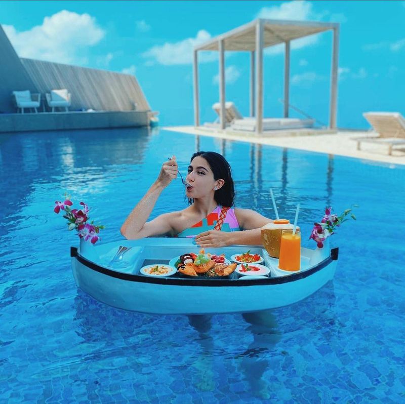 In another picture, she is having food being inside the water. Enjoying the beauty, she wrote on her post, "When Sister Sara fears post binge bloat. Brother Iggy says 'at least fatty will float'. Now that rhyme made sense so I can gloat. And to reward myself I will consume this entire boat."