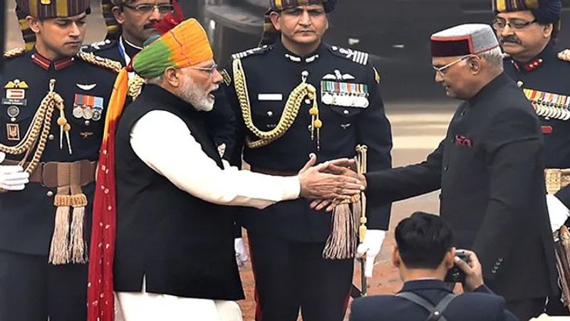 2018: प्रधानमंत्री नरेंद्र मोदी पहनावे को लेकर अक्सर चर्चा में रहते हैं। पीएम मोदी के बारे में कहा जाता है कि वह जहां कहीं भी जाते है वहां के संस्कृति को समझने की कोशिश करते हैं। इसी क्रम में 2018 में गणतंत्र दिवस के मौके पर केसरिया, हरे और लाल रंग का मिक्स साफा बांधे हुए नजर आएं। गौरतलब है की पीएम मोदी हर बार स्वतंत्रता दिवस और गणतंत्र दिवस के मौके पर साफा बांधे हुए नजर आते हैं।
