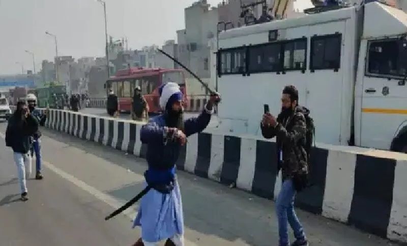 प्रदर्शनकारी के तलवार तानने की यह तस्वीर खूब वायरल हो रही है। 