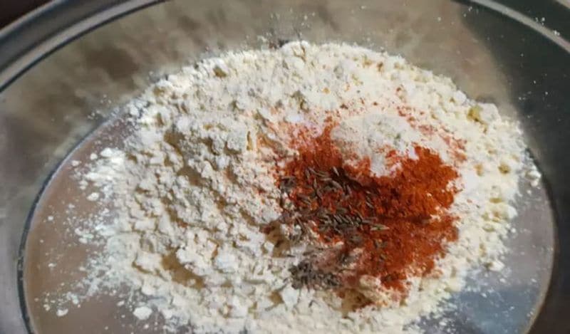 अब एक परात में बेसन निकालें। इसमें अब सभी मसाले डालें। 