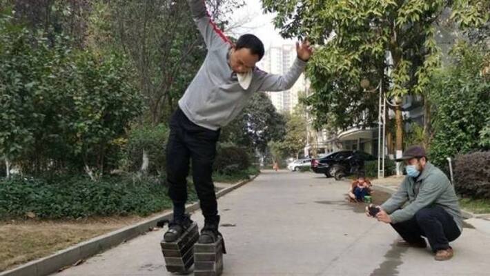 Chinese man walking with 150 kg attached to his feet Chinese man walking with 150 kg attached to his feet