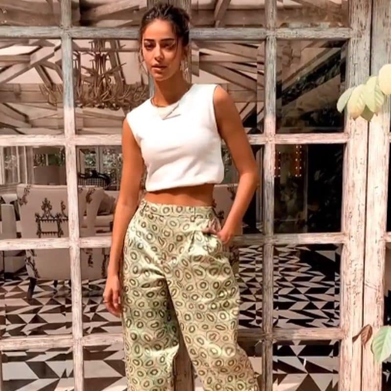 She donned in a sleeveless white crop top and paired with green printed trousers. She kept her hair in a messy bun, and for makeup, she went for minimal. She did a subtle smokey eye, nude glossy lips, contoured cheeks. She wore golden loops and a Schitt's Creek inspired necklace,
