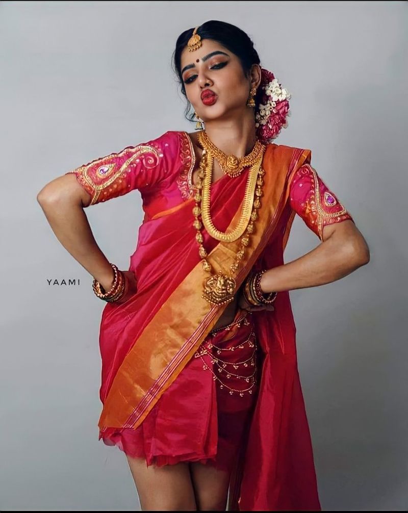 அழகு பதுமையாக சிவப்பு நிற பட்டு புடவையில்... ஆடை அலங்காரத்துடன் இருக்கும் பவி, புடவையை மட்டும் பாதி தான் அணிந்துள்ளார்.