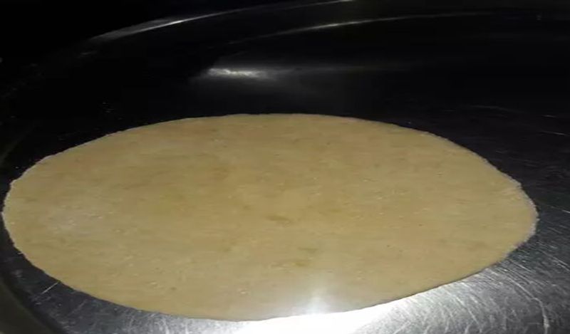 अब आटे की लोइयों को थोड़ा मोटा करके बेल लें। एक साथ तीन से चार रोटियां बेलें और फिर उसे ओवन के स्टैंड पर डाल दें।

