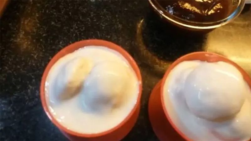 अब वडों का पानी अच्छे से निचोड़ लें और इन्हें एक बाउल में डाल लें। इनके ऊपर फेंटी हुई दही डालें।