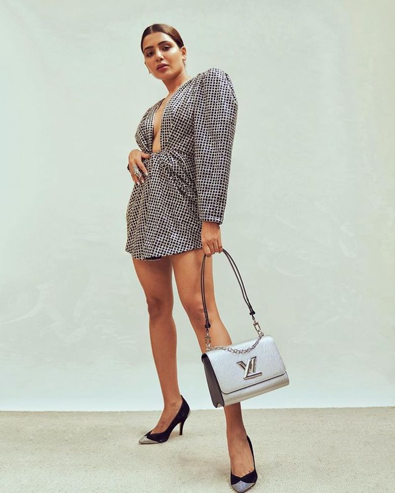 Sam is seen holding a Louis Vuitton Twist Bag and black and silver heels in the plunging neckline short dress.