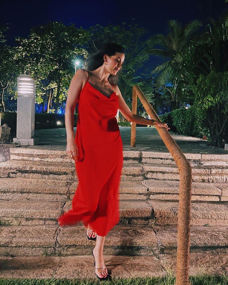 Natasa is walking in the hotel's garden, in another bold look of hers, wearing a red dress, as she dazzles in it.