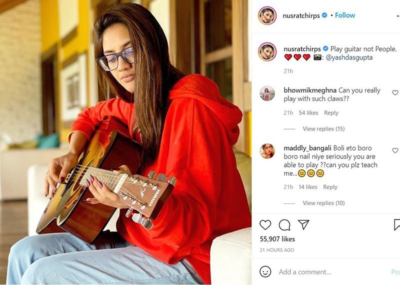 নো মেক আপ লুক, চোখে মোটা ফ্রেমের চশমা, লাল রঙের শীত পোশাকে গিটারে সুর তুলেছেন নুসরত জাহান। সোফায় বসে অবসর উপভোগ করছেন নায়িকা।