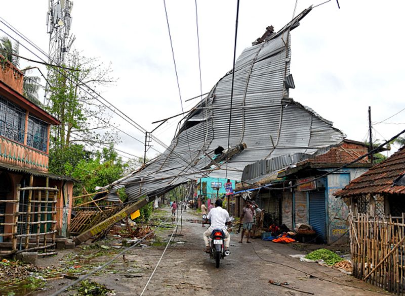 দিনটা ছিল ২১ মে। সকাল থেকেই ছিল তীব্র ঝোড়ো হাওযা ও বৃষ্টি। বিকেলে দাপত বেড়েছিল দুইয়েরই। আর মাঝের ৩০ মিনিট, ছিল শুধুই আতঙ্কের, তছনছ হয়ে গিয়েছিল দক্ষিণবঙ্গের বিস্তীর্ণ অংশ। ছবিতে দেখা যাচ্ছে একটি বাড়ির চাল উড়ে গিয়ে জড়িয়ে গিয়েছে বিদ্যুতের তারে।