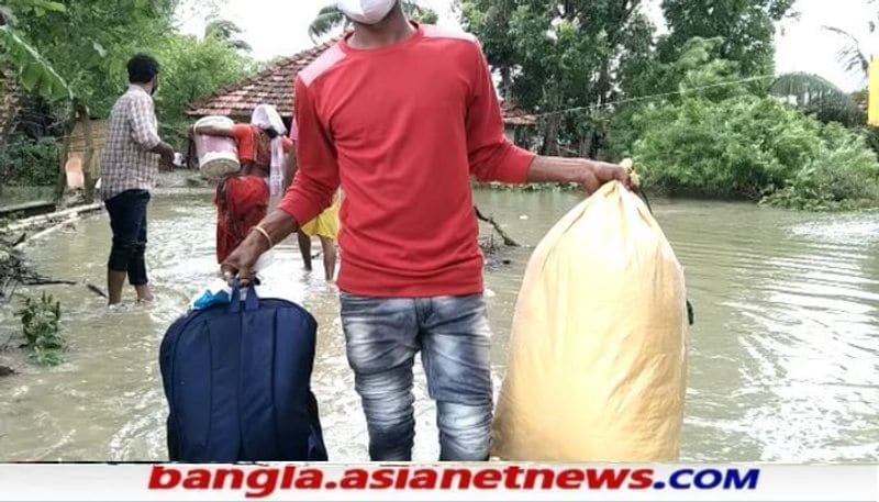 হলদিয়ায় গ্রামে জল ঢুকে পড়ায়, জিনিসপত্র নিয়ে ত্রাণ শিবিরে যাচ্ছে মানুষ।
