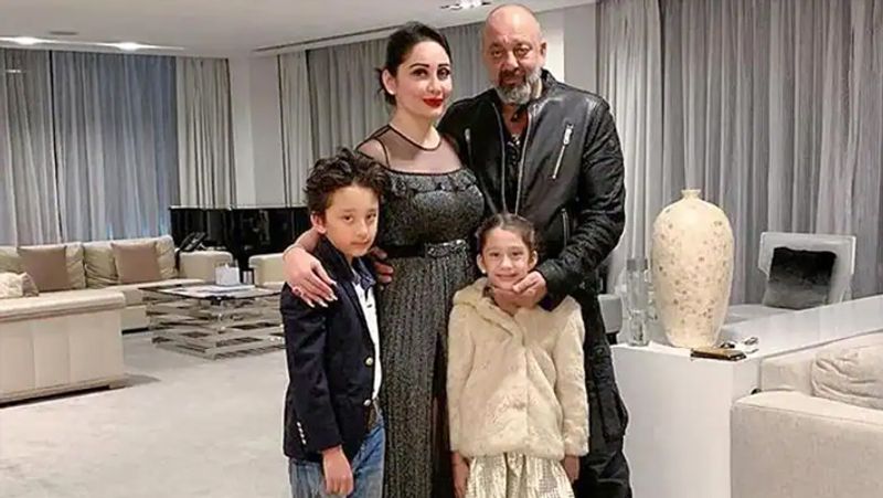 घर के ड्राइंग रूम में बड़े-बड़े सोफे और कई शोपीस लगे हैं। कमरे में सोफों की मैचिंग के पर्दे भी लगा है।
