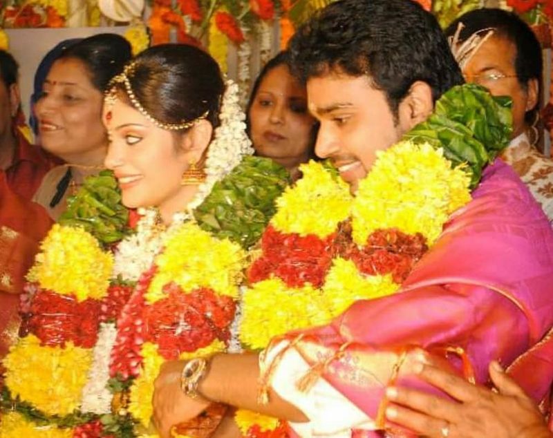 கழுத்தில் மலையோடு அமர்ந்திருக்கும் மணமகன் - மணமகள் 