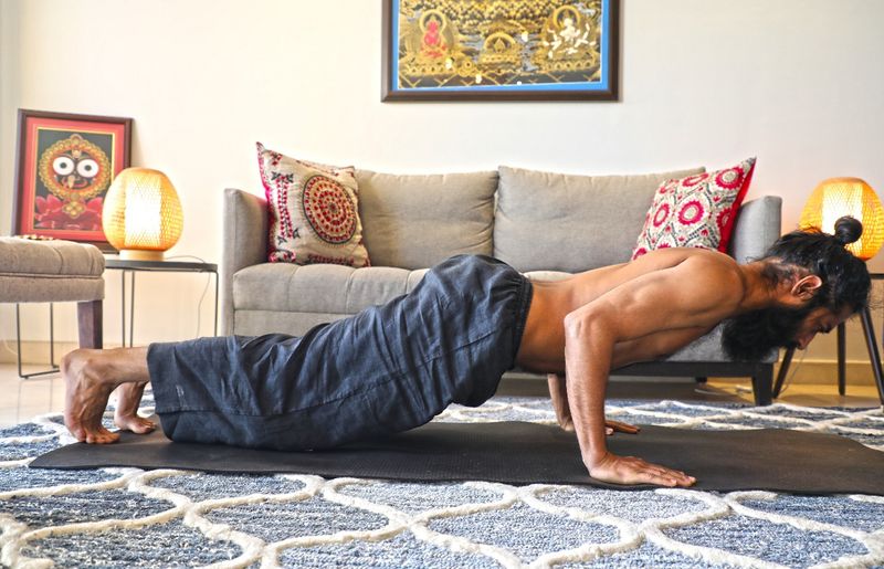 Chaturanga Dandasana
Formation of posture:
Begin with plank posture
As you exhale, lower your body down into half a push-up, such that the upper
arms are parallel to the floor
Your elbows must touch the sides of your ribs as you lower yourself to maintain a 90-degree angle in the crook of the elbows
Your shoulders must be drawn in
Your wrists and elbows must be perpendicular to the floor and your shoulders must be in line with your body