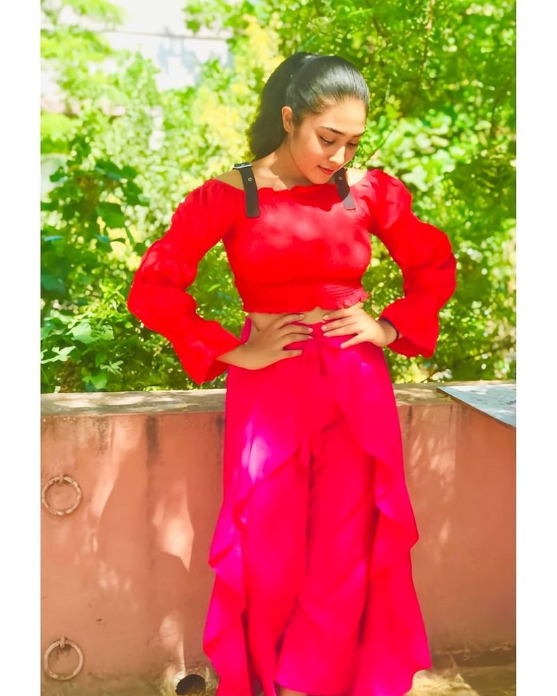 சிவப்பு நிற ரோஜாவைப்போல் இடுப்பில் கை வைத்து போஸ் 