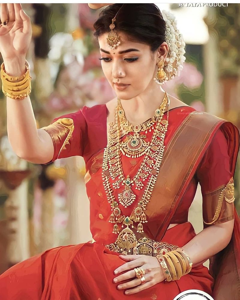 சிம்பிளான சிவப்பு நிற பட்டுப்புடவையில், தலை நிறைய மல்லிகைப்பூ, உச்சி முதல் பாதம் வரை ஜொலி ஜொலிக்கும் நகைகள் அணிந்து, தலை குனிந்த படி அமர்ந்திருக்கும் நயனின் இந்த க்யூட் போட்டோஸ் லைக்குகளை அள்ளி வருகிறது. 