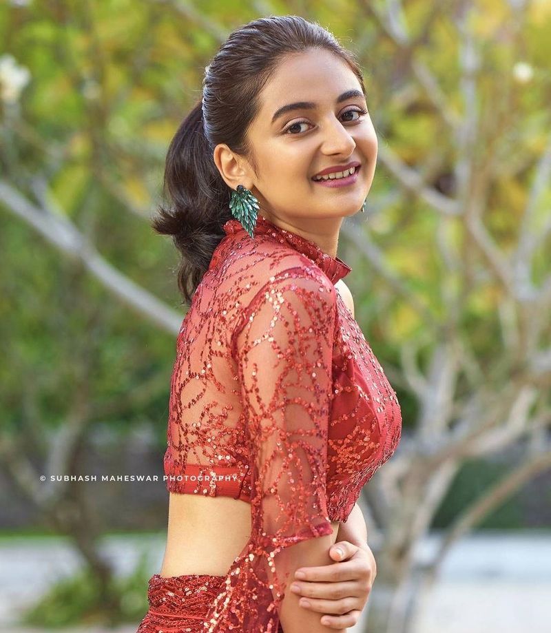 சிவப்பு நிற டாப் அணிந்து, ஸ்டைலிஷ் போஸ் கொடுக்கும் எஸ்தர் 