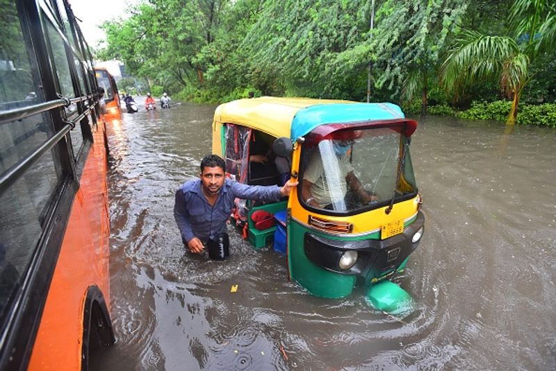വള്ളക്കെട്ടില് നിന്ന് തന്റെ ്ഒട്ടോറിക്ഷയെ പുറത്ത്കടത്താന് ശ്രമിക്കുന്നയാള്. ഒരു മുംബൈക്കാഴ്ച. 