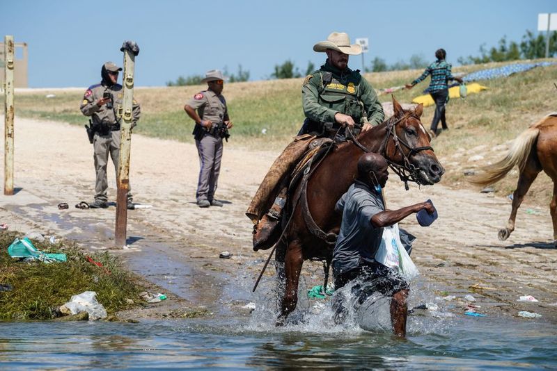 Shocking images of horse mounted US police officers whipping Haitian migrants on US Mexico border
