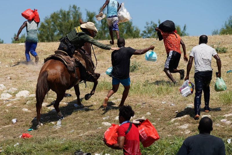 Shocking images of horse mounted US police officers whipping Haitian migrants on US Mexico border