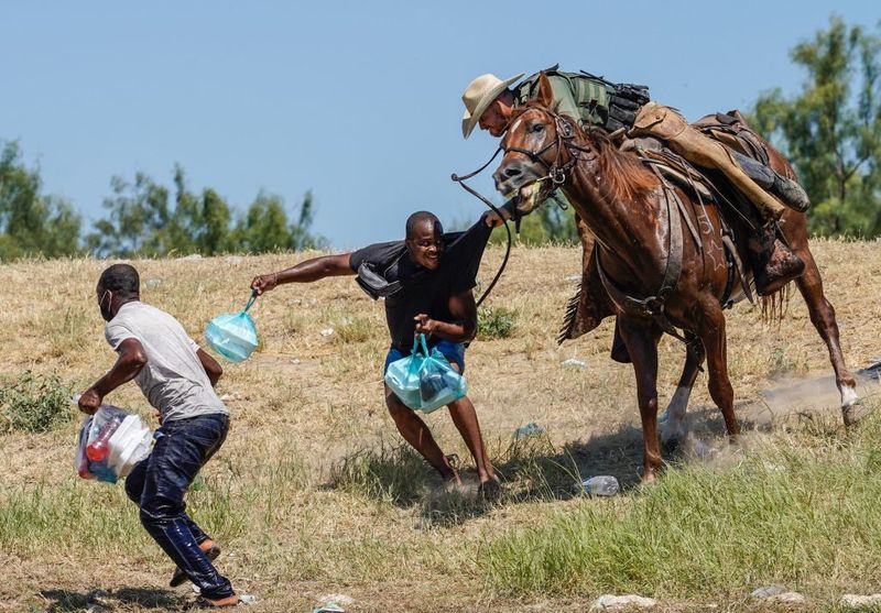 Shocking images of horse mounted US police officers whipping Haitian migrants on US Mexico border