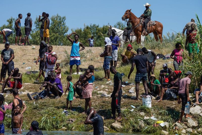 Shocking images of horse mounted US police officers whipping Haitian migrants on US Mexico border
