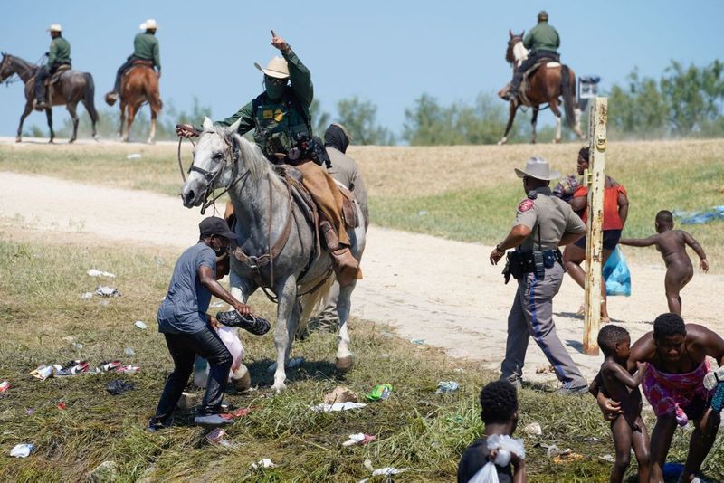 Shocking images of horse mounted US police officers whipping Haitian migrants on US Mexico border