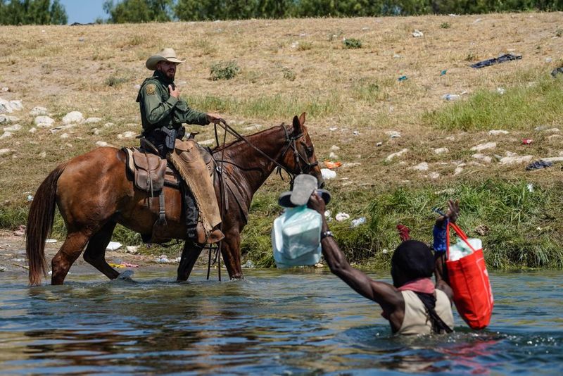 Shocking images of horse mounted US police officers whipping Haitian migrants on US Mexico border