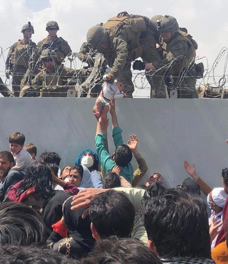 iconic photo baby lifted over wall at Kabul airport by Marine