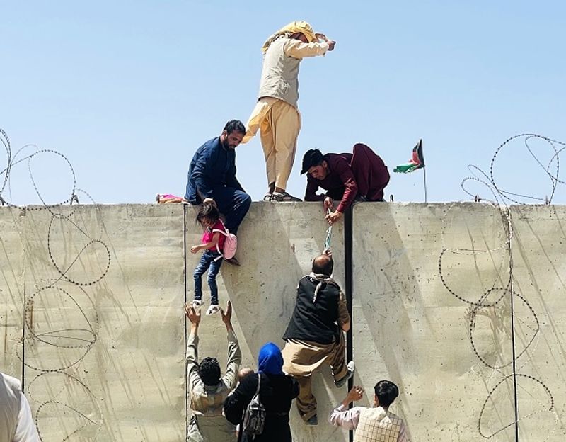 iconic photo baby lifted over wall at Kabul airport by Marine